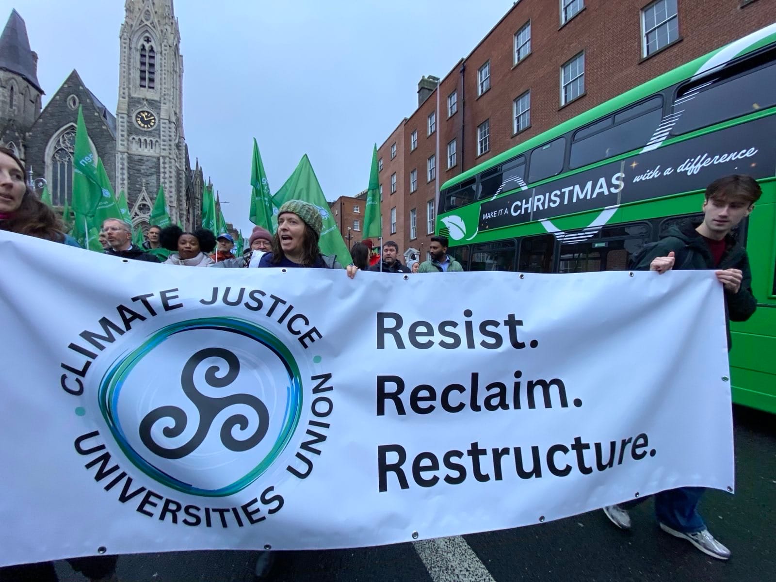 Photograph of CJUU marchers, with flags and banners, on the streets of Dublin.